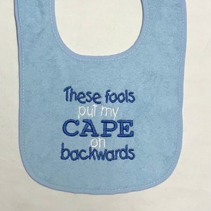 These fools put my cape on backwards embroidered bib