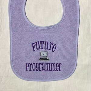May include: Purple baby bib with the text "Future Programmer" and a small embroidered image of a computer.