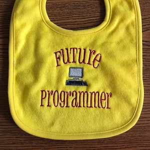May include: Yellow baby bib with red embroidery that says "Future Programmer" and a small image of a computer.