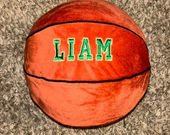 May include: A plush orange basketball with black stitching and the name "LIAM" embroidered in green.
