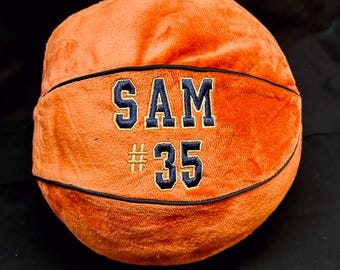 May include: Orange plush basketball with black stitching and a navy blue embroidered name "SAM #35" on the front.