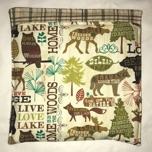 Puede incluir: Una tela de color crema con un tema de bosque. La tela presenta una variedad de animales, incluidos búhos, alces y lobos. La tela también presenta árboles, hojas y las palabras "Home is in the Woods", "Live Love Lake", "Owl Always", "Moose Through the Woods", "Be Leaf in Nature", "On Living Lodge Time", "Log On To Nature", "Live Large the Lake" y "One Two Tree There's Nowhere I'd Rather Be".