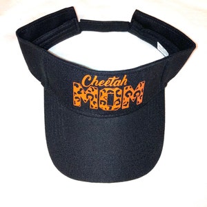 May include: Black visor with an orange cheetah print "Cheetah Mom" design.