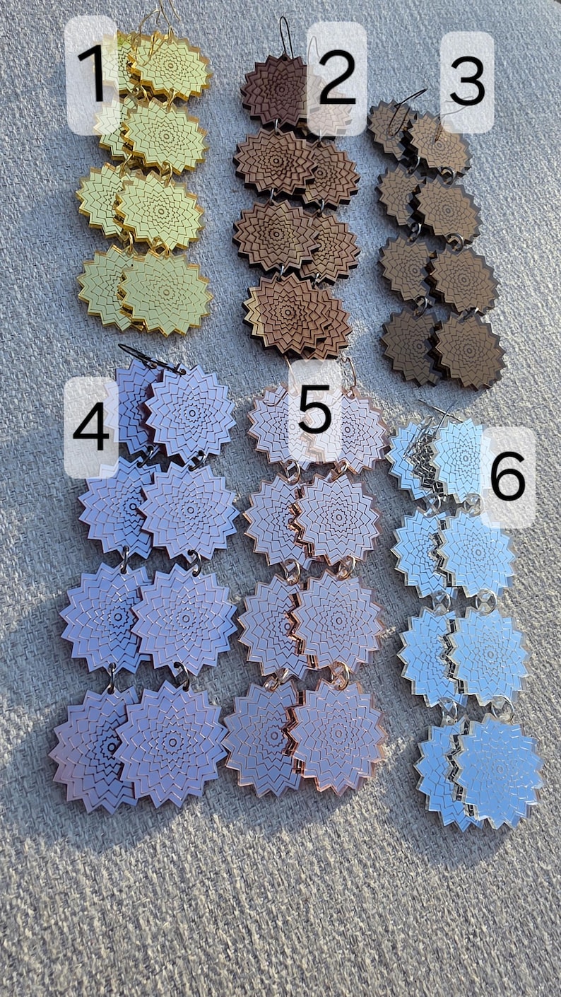 Puede incluir: Colecci&oacute;n de seis pares de pendientes con un dise&ntilde;o floral &uacute;nico. Los pendientes est&aacute;n disponibles en oro, marr&oacute;n y tonos de azul y morado. Fabricados con un material reflectante.
