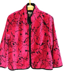 May include: A pink and black patterned jacket with a zipper closure. The jacket has a mandarin collar and a black trim.