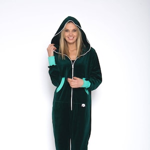 May include: A dark green hooded jumpsuit with a white zipper and turquoise trim. The jumpsuit has a pocket on each side and a small logo on the left leg.