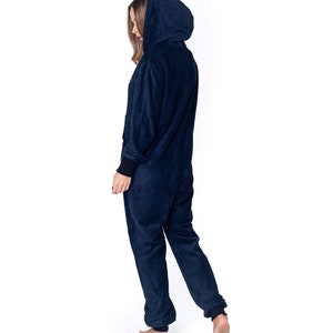 May include: A navy blue hooded onesie with long sleeves and a zipper closure. The onesie is made of a soft, plush fabric.
