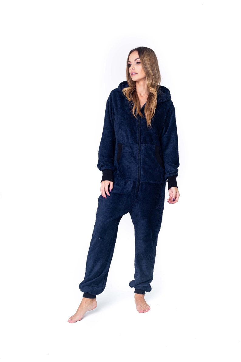 May include: A navy blue hooded jumpsuit with a zipper closure. The jumpsuit is made of a soft, fuzzy material.