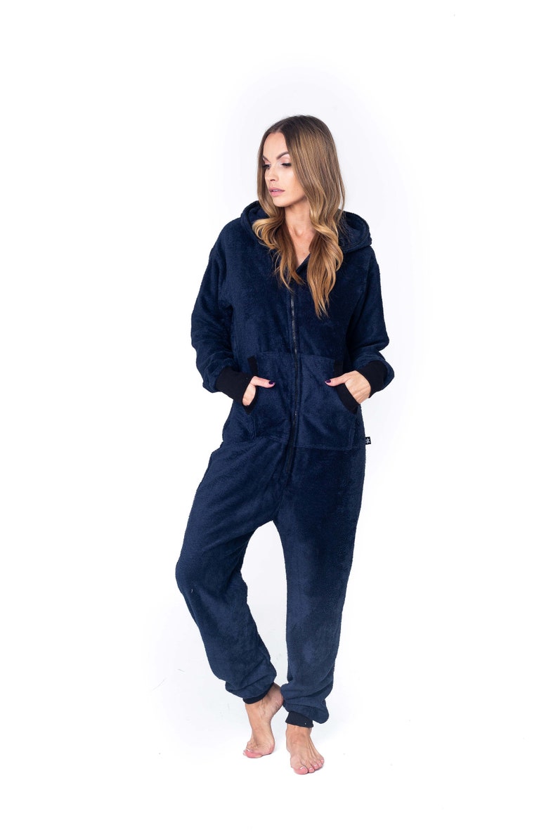 May include: A navy blue hooded jumpsuit with a zipper closure and pockets. The jumpsuit is made of a soft, fuzzy material.