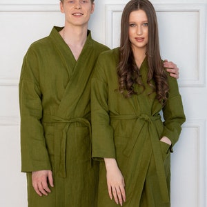 May include: Two people wearing matching olive green linen robes. The robes have a shawl collar and a tie belt.
