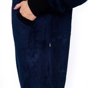 May include: A dark blue fleece jumpsuit with a black zipper and a black pocket on the left side.
