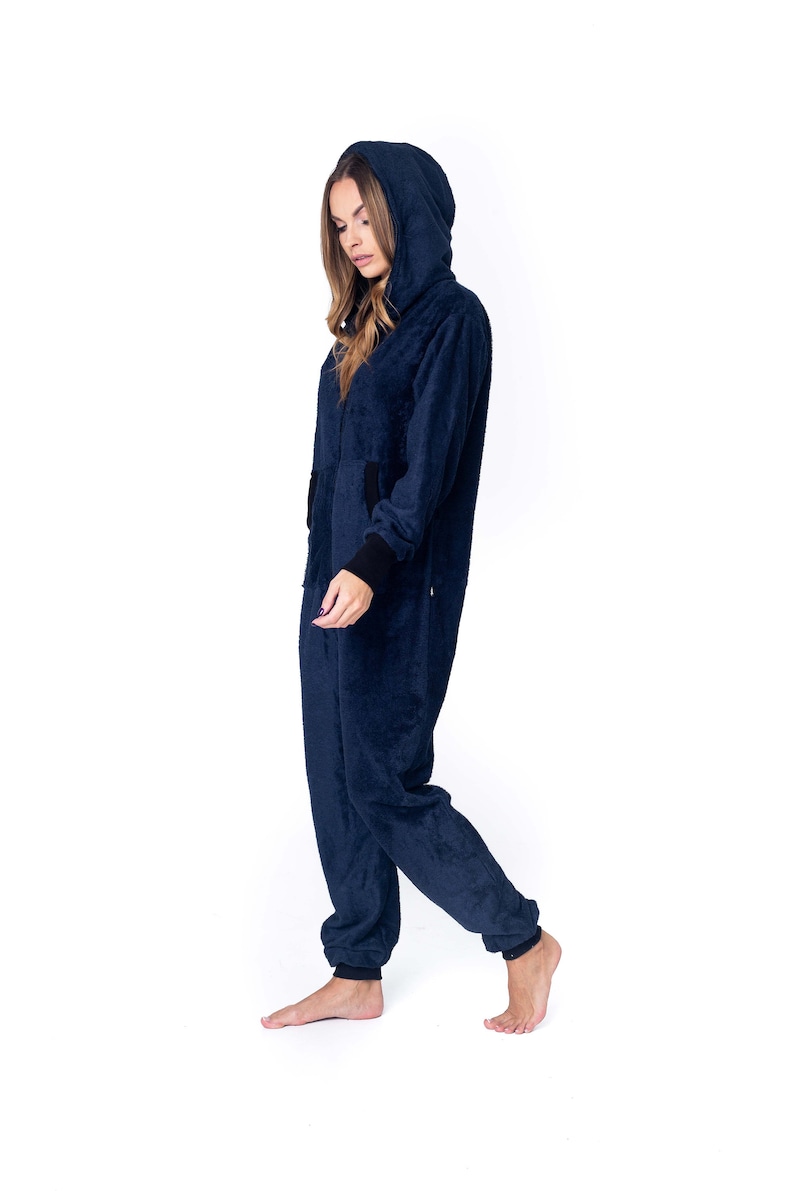 May include: A navy blue hooded jumpsuit with a zipper closure. The jumpsuit has a soft, fuzzy texture.