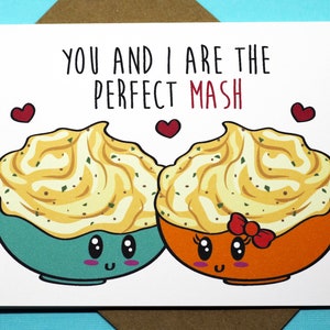 May include: A white card with the text "You and I are the perfect mash" in black. Two cartoon bowls of mashed potatoes with faces are on either side of the text. The bowls are facing each other and have hearts above them.