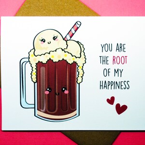 May include: A white card with a cartoon illustration of a root beer float with a red and white striped straw. The text "You are the ROOT of my HAPPINESS" is written in black with the word "ROOT" in red. Two small red hearts are at the bottom of the card.