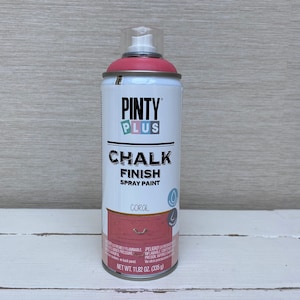 May include: A can of Pinty Plus Chalk Finish spray paint in coral. The can is white with a pink top and features the brand name and product description. The net weight is 335 g.