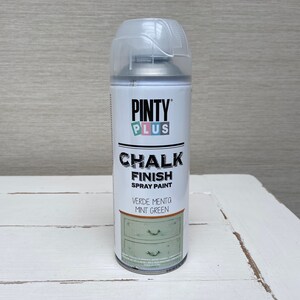 May include: A can of Pinty Plus Chalk Finish spray paint in Mint Green. The white can has a clear plastic cap and features the brand name and product information. The label shows a mint green dresser.
