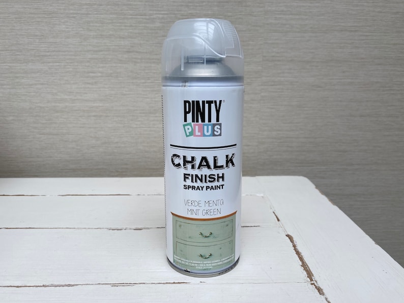 May include: A can of Pinty Plus Chalk Finish spray paint in Mint Green. The white can has a clear plastic cap and features the brand name and product information. The label shows a mint green dresser.