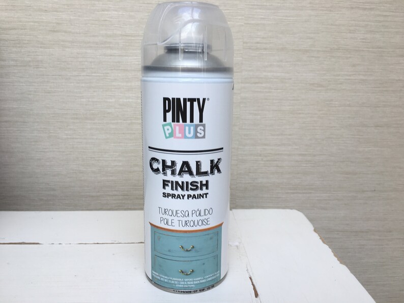 May include: A can of Pinty Plus Chalk Finish spray paint in turquoise. The white can has black and turquoise text, and a clear plastic cap. The label shows a turquoise cabinet illustration.