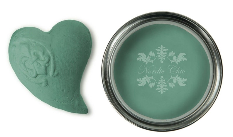 May include: A teal green paint sample in a heart shape and a can of teal green paint with the text "Nordic Chic" on the label.