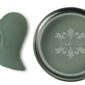 May include: A small sample of green paint in a heart shape and a can of green paint with the text "Nordic Chic" on the label.