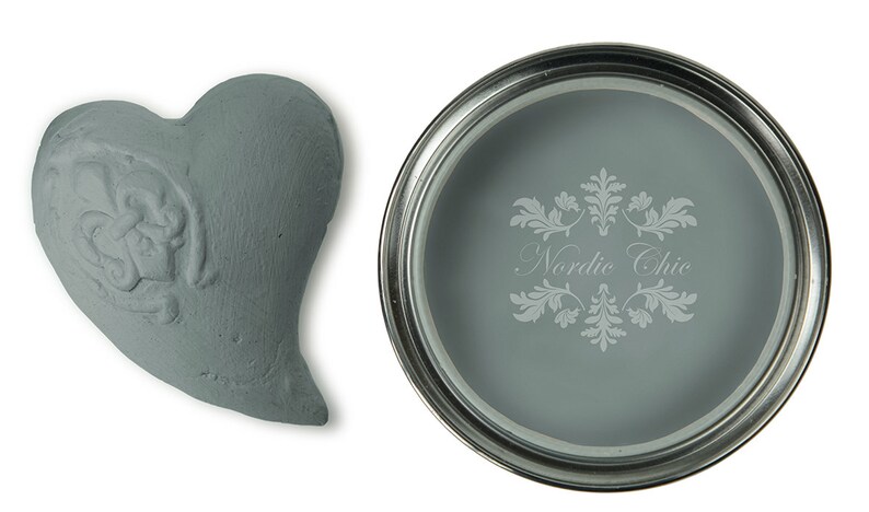 May include: A sample of light blue paint in a heart-shaped container and a paint can with the text "Nordic Chic" on the label.