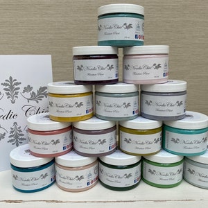 May include: A collection of 15 paint jars in various colours, including teal, green, yellow, purple, and pink. Each jar is labelled "Nordic Chic" and "Furniture Paint".