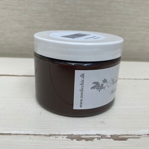 K&ouml;nnte beinhalten: Ein braunes Glas mit Farbe, einem wei&szlig;en Deckel und einem Etikett mit der Aufschrift "www.nordicchic.dk".