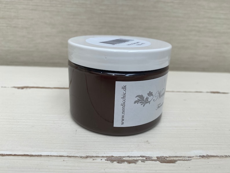 K&ouml;nnte beinhalten: Ein braunes Glas mit Farbe, einem wei&szlig;en Deckel und einem Etikett mit der Aufschrift "www.nordicchic.dk".