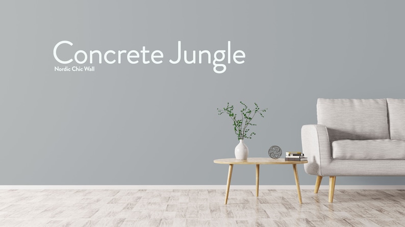 May include: A light gray wall with the text "Concrete Jungle" and the words "Nordic Chic Wall" below it. A white couch with wooden legs sits in front of the wall. A small wooden table with a vase of green plants sits in front of the couch.