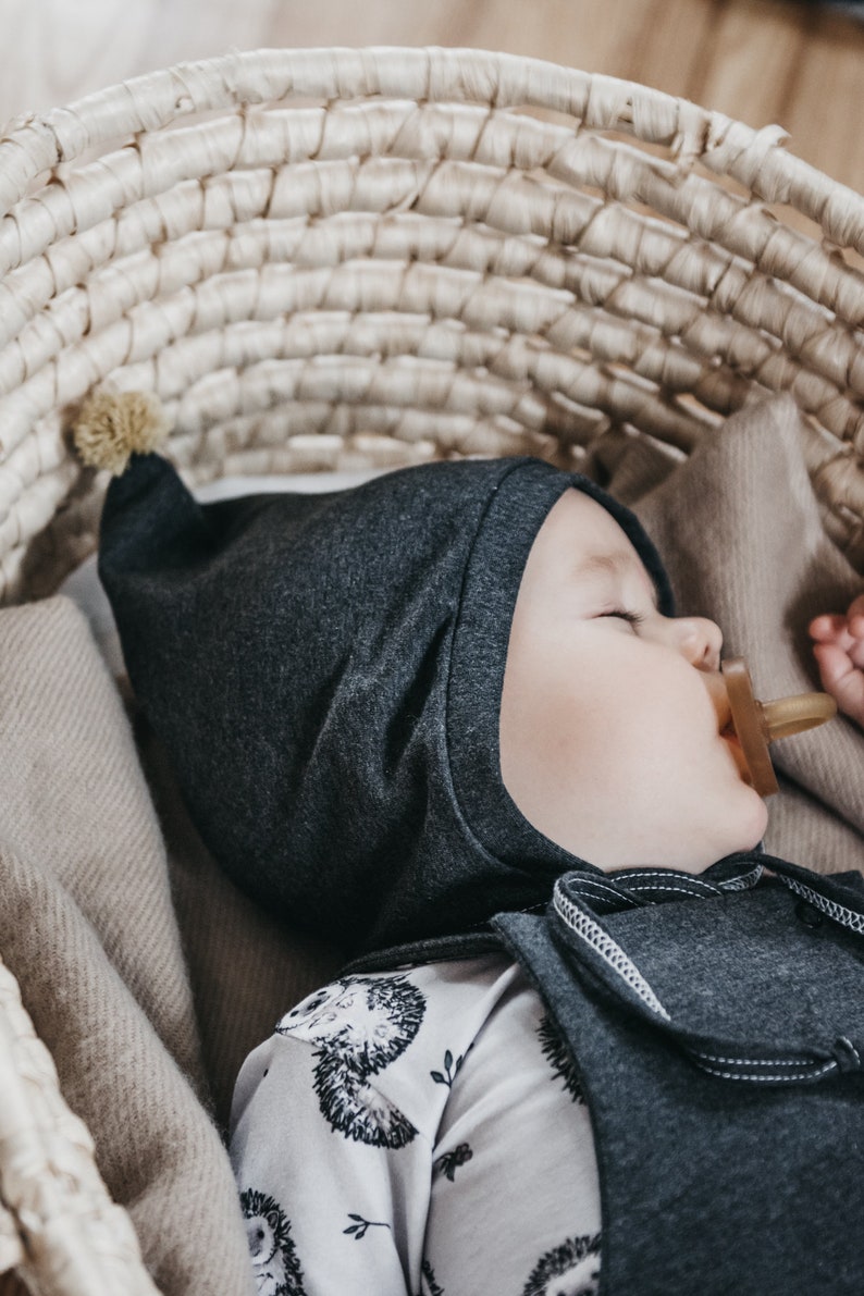 Cappello da bambino grigio scuro con pompon di senape, cappello da nano per neonato, cappello da pilota per neonato in cotone organico, cappello a cuffia per neonato, primo cappello da neonato, cappello legato immagine 2