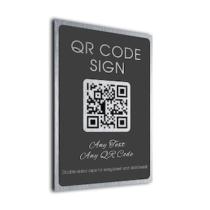 Könnte beinhalten: Ein rechteckiges Schild mit einem gebürsteten silbernen Metallrand und einer dunkelgrauen Mitte. Der Text lautet QR CODE SIGN, Any Text, Any QR Code und Double sided tape for easy (peel and stick) install, mit einem zentralen QR-Code.