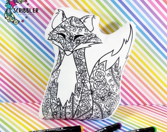 May include: A white plush pillow shaped like a fox with a floral design. The pillow is ready to be coloured in with markers. Three black markers with the text "Scribbler Experiment" are in the foreground.