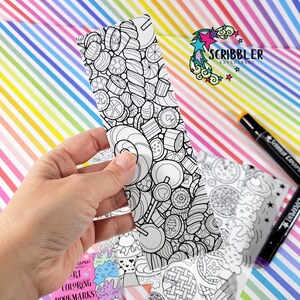 May include: A black and white bookmark with a candy theme. The bookmark is part of a set of coloring bookmarks. The bookmark is held in a hand. The text "Scribbler Experiment" is visible in the background.