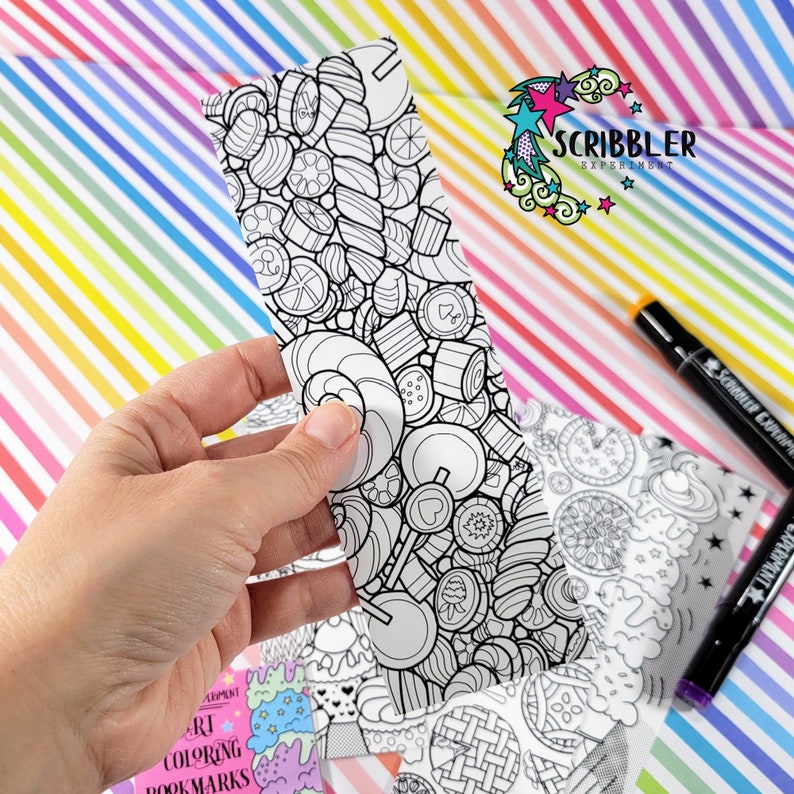 May include: A black and white bookmark with a candy theme. The bookmark is part of a set of coloring bookmarks. The bookmark is held in a hand. The text "Scribbler Experiment" is visible in the background.