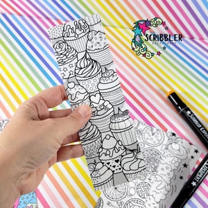 May include: A black and white bookmark with a pattern of cupcakes and hearts. The bookmark is made of paper and is designed to be colored in. The bookmark is part of a set of coloring bookmarks.