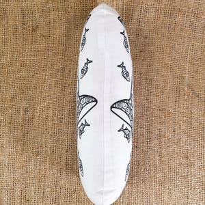 May include: White pillow with a black and white design of fish and whales. The pillow is oval shaped and has a white background.