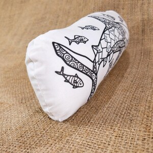 May include: White pillow with a black and white design of a fish with swirls and other fish swimming around it.
