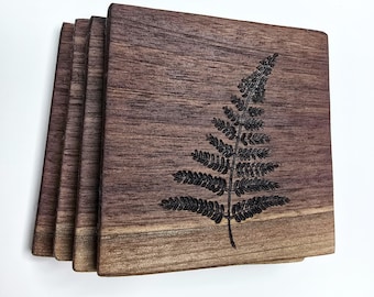 May include: Set of four brown wooden coasters with a laser-etched fern design.