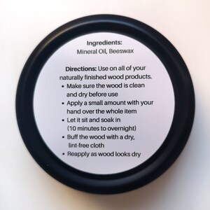 May include: Black and white label with instructions for using wood oil. The label reads "Ingredients: Mineral Oil, Beeswax" and "Directions: Use on all of your naturally finished wood products. &bull; Make sure the wood is clean and dry before use &bull; Apply a small amount with your hand over the whole item &bull; Let it sit and soak in (10 minutes to overnight) &bull; Buff the wood with a dry, lint-free cloth &bull; Reapply as wood looks dry"