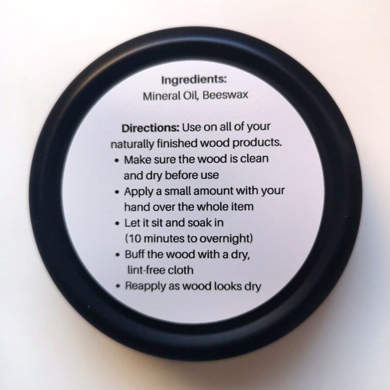 May include: Black and white label with instructions for using wood oil. The label reads "Ingredients: Mineral Oil, Beeswax" and "Directions: Use on all of your naturally finished wood products. &bull; Make sure the wood is clean and dry before use &bull; Apply a small amount with your hand over the whole item &bull; Let it sit and soak in (10 minutes to overnight) &bull; Buff the wood with a dry, lint-free cloth &bull; Reapply as wood looks dry"