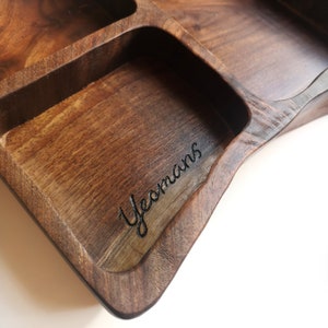 May include: A wooden tray with multiple compartments, featuring a personalised inscription that reads "Yeomans".