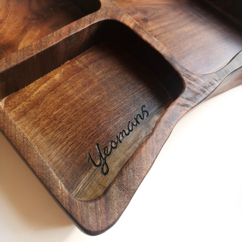May include: A wooden tray with multiple compartments, featuring a personalised inscription that reads "Yeomans".