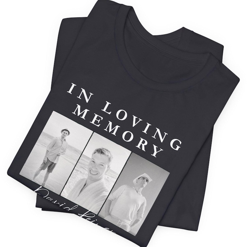 May include: Black t-shirt with the text "IN LOVING MEMORY" above three black and white photos. The name "David" is printed below the photos in cursive. The t-shirt is folded.