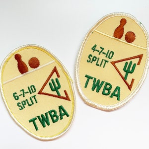 May include: Two embroidered patches with a light yellow background and a white border. Each patch features a bowling pin and ball, the text "SPLIT", a cactus symbol, and the letters "TWBA". One patch reads "6-7-10 SPLIT", the other reads "4-7-10 SPLIT".