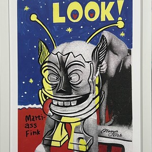 May include: Framed artwork featuring a stylized alien-like figure with a large grin and a red tongue. The background is blue with white stars and the word "LOOK!" in yellow. The artwork includes the text "Marti-ass Fink".