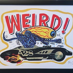 May include: Framed art print featuring a cartoon alien with a large eye and a blue creature driving a black race car with flames. The word "WEIRD!" is in red with a yellow border.