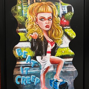 May include: A cartoon illustration of a woman in a white dress and black leather jacket standing on a stack of blue boxes. The background is a suburban street scene. The text "BEAT IT CREEP" is written in blue letters on the sidewalk.