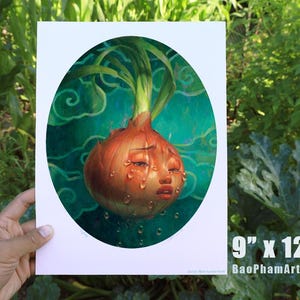 Pu&ograve; includere: Una stampa artistica di una cipolla che piange con un volto umano, su uno sfondo verde acqua con motivi a vortice. L'opera d'arte &egrave; in una cornice ovale e misura 23 cm x 30 cm.