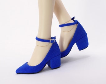 May include: A pair of bright blue, suede-like heels with ankle straps and block heels. The shoes have a pointed toe and a buckle closure on the ankle strap. The heels appear to be approximately 2 inches high.