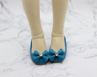 May include: A pair of teal blue ballet flats with a small bow and a rhinestone accent on each shoe.
